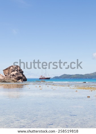 Seychelles - November 6, 2014: Beautiful seascape with a huge stone and the yacht is sailing against the wind along the Seychelles in the Indian Ocean November 6, 2014, Seychelles