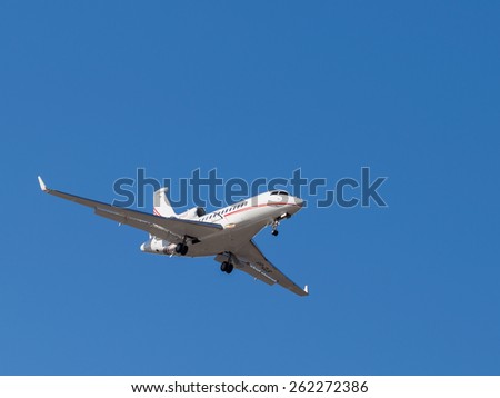 Sheremetyevo - March 14, 2015: Beautiful Airplane Falcon 7x, is landing at Sheremetyevo Airport on a background of bright blue sky March 14, 2015, Sheremetyevo, Moscow Region, Russia