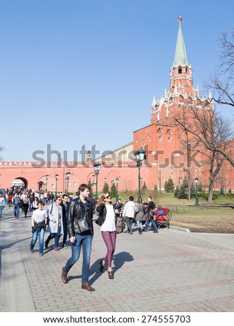Moscow - April 12, 2015: A tourist place in Moscow - Alexander Garden and many tourists relax in the center of town and is visible Trinity Tower of the Kremlin April 12, 2015, Moscow, Russia