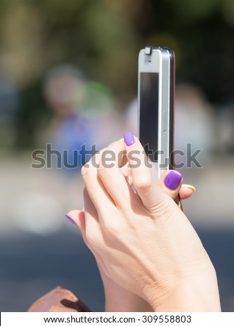 Women\'s hands with lilac manicure push buttons on phone did not recognize