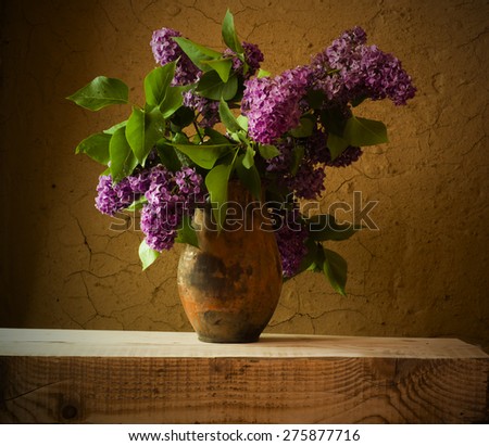 Still life with blooming branches of lilac in vases