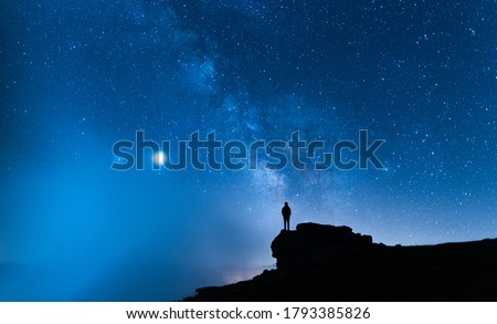 Person contemplating the vastness of the universe. Small silhouette of a man under the Milky Way and the magical starry sky. Concept of human smallness. Foto stock © 