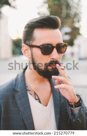 young man smoking cigarette in the street