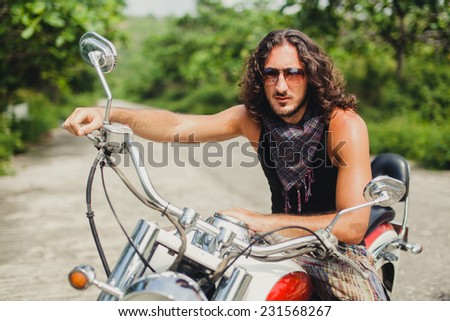 young man posing on a motorcycle on the road