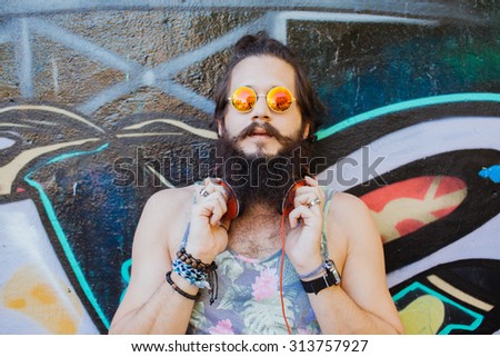 lifestyle portrait of teen man outdoors portrait,car trip.Happy and active.mans hairstyle.trendy man sunglasses,sport style,young dj,t-shirt and shorts,Cool man with beard.big earphones,success