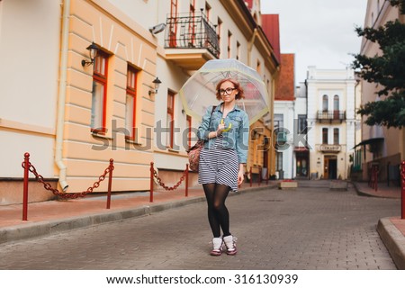 unny Outdoor summer lifestyle image of young pretty hipster woman having fun, listening music and walking on the street, city center Europe, cute white vintage outfit and sunglasses, fun joy, emotions