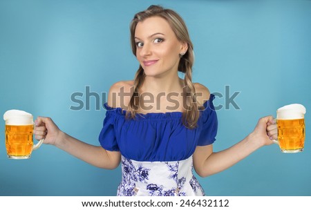 Funny girl with pigtails and glasses of beer on a blue background