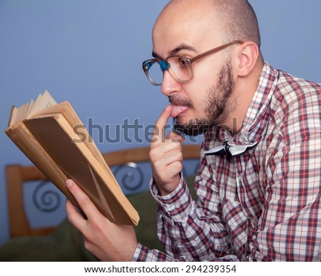 Funny nerd reading a book in the interior