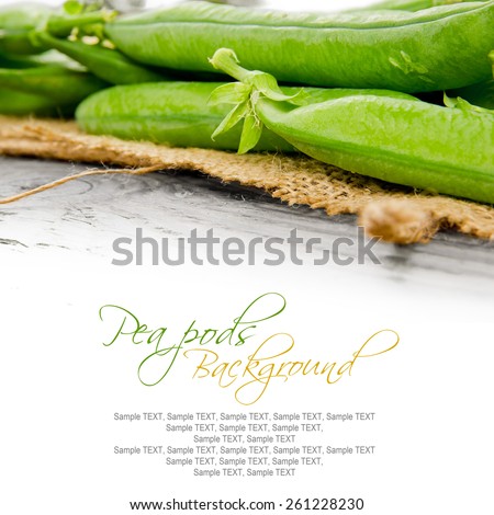 Photo of pea pods on wooden board with white space