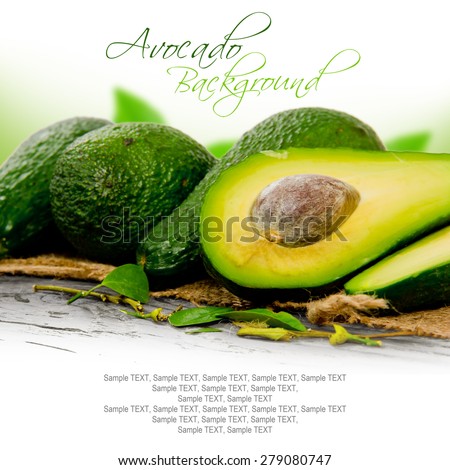 Photo of avocados with slice and leaves on burlap and wooden board