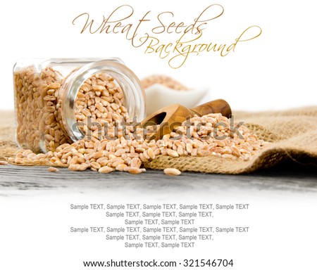 Photo of glass spicebox full of wheat seeds on burlap with white space