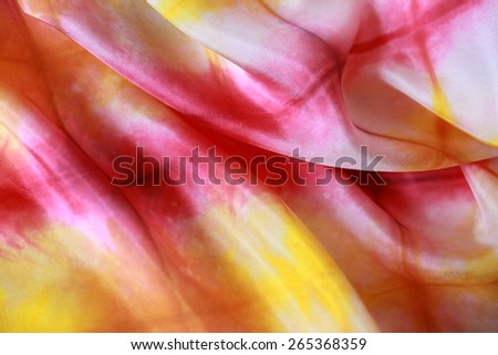 Silk background in hot colors.Rippled surface of light silk  dyed in vibrant shades of pink  and yellow, forming irregular pattern. Expression of joy, happiness.