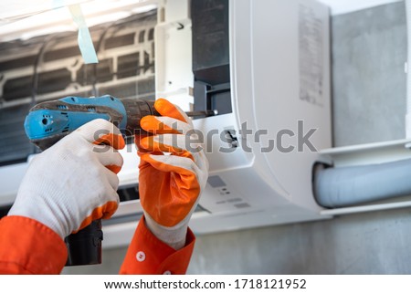 A young Asian air conditioner technician or air-conditioning installation technician is about to repair air conditioning in homes and buildings. ストックフォト © 