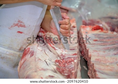 Close-up of raw meat cutting with a knife in an abattoir doing butchering and trimming of wagyu beef in the meat industry. Wagyu beef slices in beef cattle restaurants in many parts of Japan. Сток-фото © 