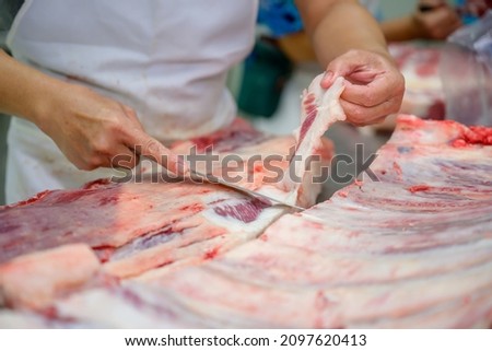 Close-up of raw meat cutting with a knife in an abattoir doing butchering and trimming of wagyu beef in the meat industry. Wagyu beef slices in beef cattle restaurants in many parts of Japan. Сток-фото © 