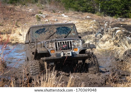 KINGSTON, NOVA SCOTIA, CANADA - APRIL 17, 2008:  A Jeep YJ blasts through a mud bog without getting stuck.