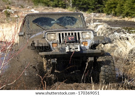 KINGSTON, NOVA SCOTIA, CANADA - APRIL 17, 2008:  A Jeep YJ blasts through a mud bog without getting stuck.
