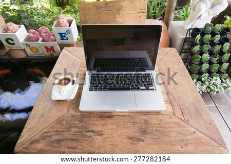laptop on wooden table in garden