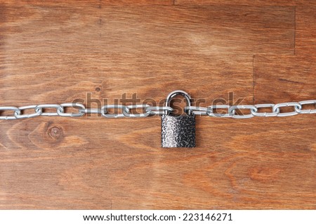 Wooden surface with chains and lock, concept of security
