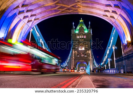 Tower Bridge in London, UK at night with moving red bus , long exposure