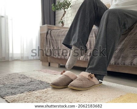 Women's feet in socks put on house slippers. Warm feet Foto d'archivio © 