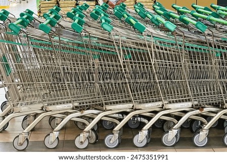 Similar – Image, Stock Photo Lined up shopping trolleys made of shiny wire with red plastic in front of a new supermarket in Bielefeld in the Teutoburg Forest in East Westphalia-Lippe