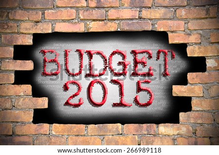 The budget 2015 reveal behind the brick wall with digital information background