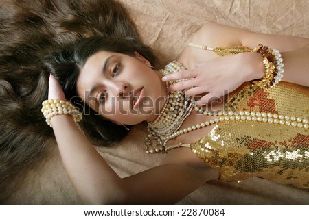 pretty girl in gold dress and pearls with long hair