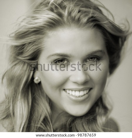 Model with pretty smile and hair blowing in the wind