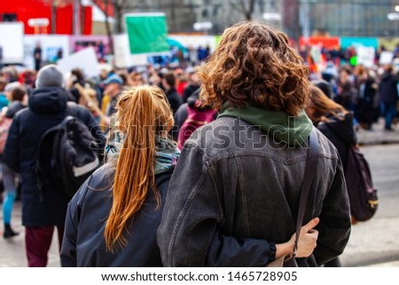 People gather for climate change. Two young people are seen from the back, watching a crowded demonstration of people against global warming on a street in Montreal, Canada Stock fotó © 