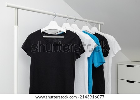 Group of Assorted t-shirts hanging on white hangers. Clothing rack. Template, mock up. Stock foto © 