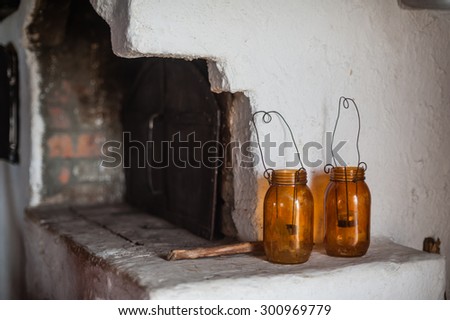 two brown glass jars work like lamp with candles on rural oven