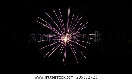 Isolated purple burst of fireworks against black sky background