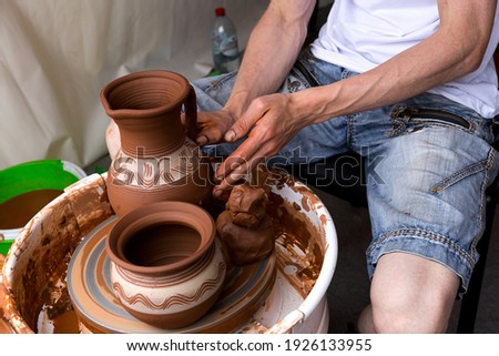 A man creates pottery on a Potter's wheel. Close-up of the Potter's hand. Сток-фото © 