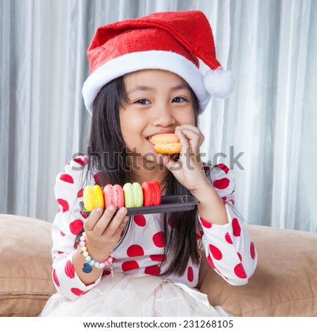 Little Girl With a Plate of Cookies and Macaroon for Santa / eating christmas cookies isolated on white background