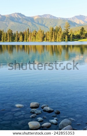Mountains and Evergreen Forest Reflected in Blue Lac Beauvert, Jasper National Park, Alberta, Canada