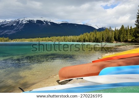 Brightly Colored Canoes on the Shore of Crystal Clear Lake