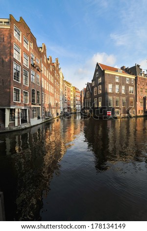 Historic houses with reflections on a canal water in Amsterdam, Netherlands.