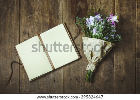 Open Sketchbook with  Pink and Blue flowers over vintage retro wooden table background. Mock up