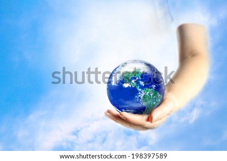 Woman holding globe on her hand with blue sky background. Elements of this image furnished by NASA