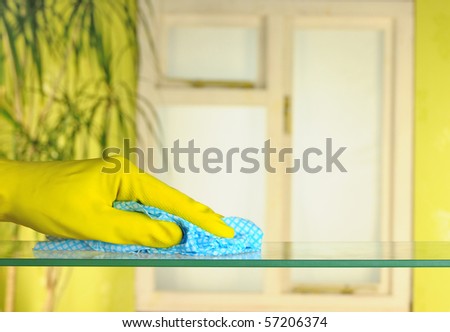 person in rubber gloves using a blue duster