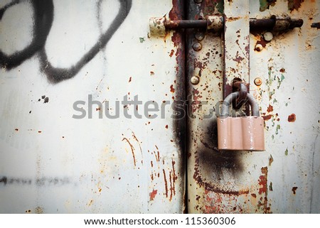 Close-up on old rusty lock on grunge metal door