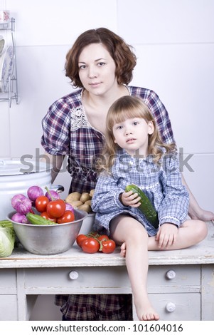 the little lovely girl with mother in kitchen learns to prepare