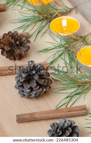 christmas decoration with cinnamon sticks, candles, pine cones and twigs