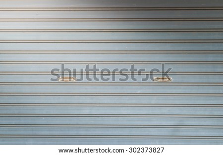 illuminated grunge metallic roller auto shutter door with light from corner