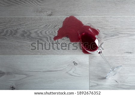 Wooden floor with overturned glass of red wine. Spilled wine on a wooden laminate (parquet) floor with moisture protection. Foto stock © 
