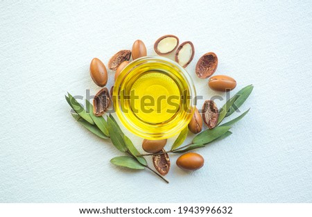 Argan seeds and oil isolated on a white background. Argan oil nuts with plant. Cosmetics and natural oils background