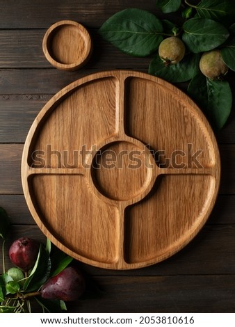 Portion wooden dish on dark wooden background. Wooden plate divided into equal 4 section. Empty compartmentals dish for food, nuts, dessert, fruit and vegetable. Wooden dishes with gravy boat 商業照片 © 