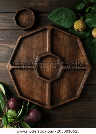 Portion dark wooden dish on dark wooden background. Wooden plate divided into equal 4 section. Empty compartmentals dish for food, nuts, dessert, fruit and vegetable. Wooden dishes with gravy boat 商業照片 © 