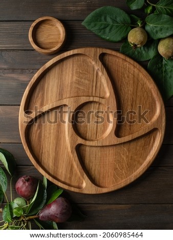 Portion wooden dish on dark wooden background. Wooden plate divided into equal 4 section. Empty compartmentals dish for food, nuts, dessert, fruit and vegetable. Wooden dishes with gravy boat 商業照片 © 